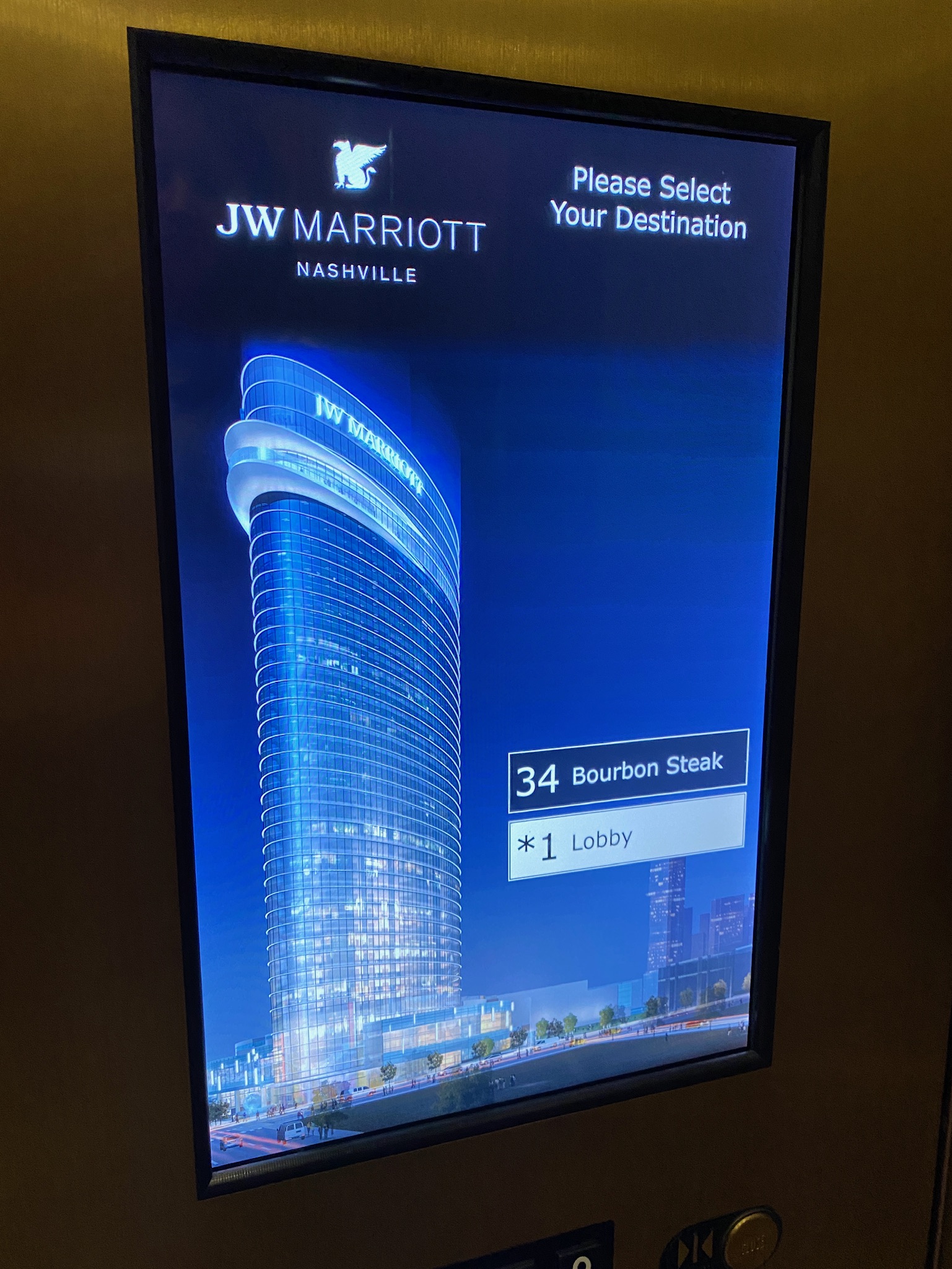 Elevator screen at JW Marriott Nashville displaying a digital image of the hotel, floor options, and current selection of Bourbon Steak on the 34th floor and Lobby.