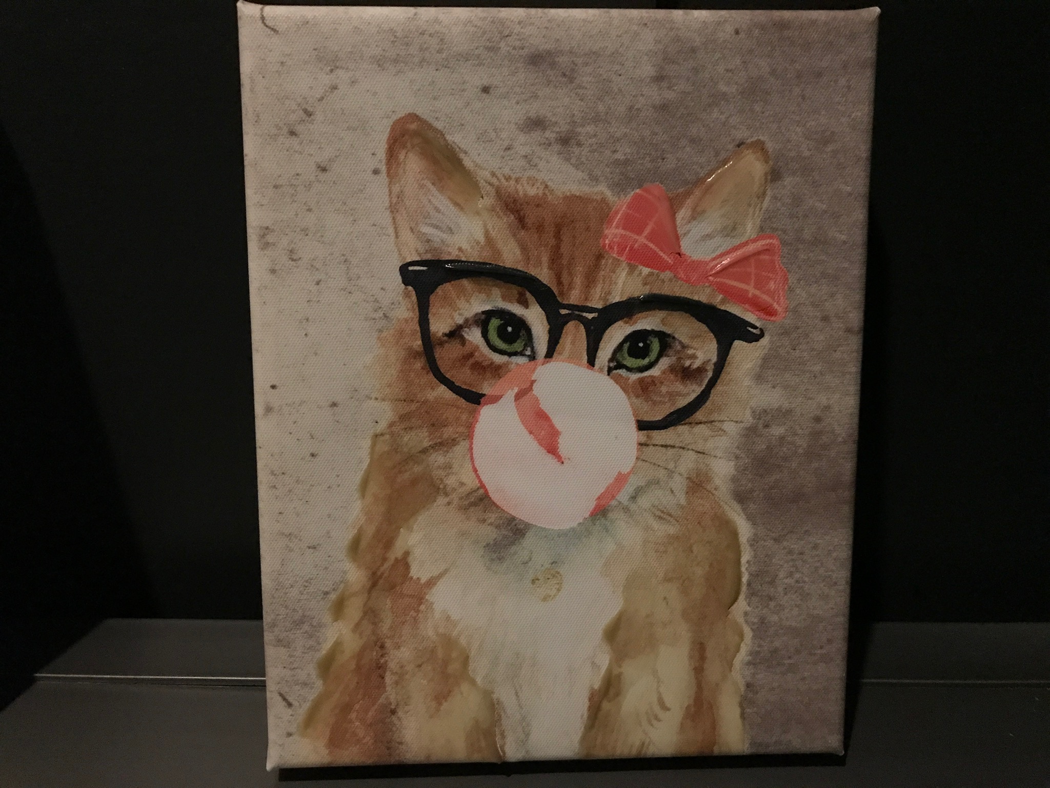 A painting of a cat wearing black glasses and a red bow, blowing a pink bubblegum bubble, on a gray background.
