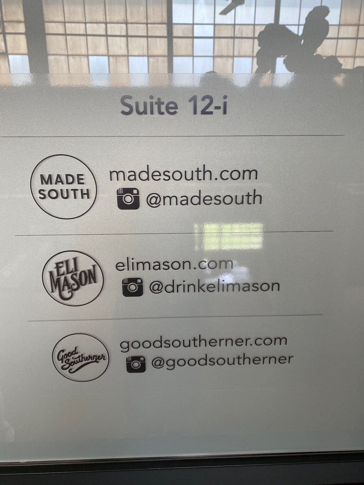 A sign displays Suite 12-i with website URLs and Instagram handles for Made South, Eli Mason, and Good Southerner.