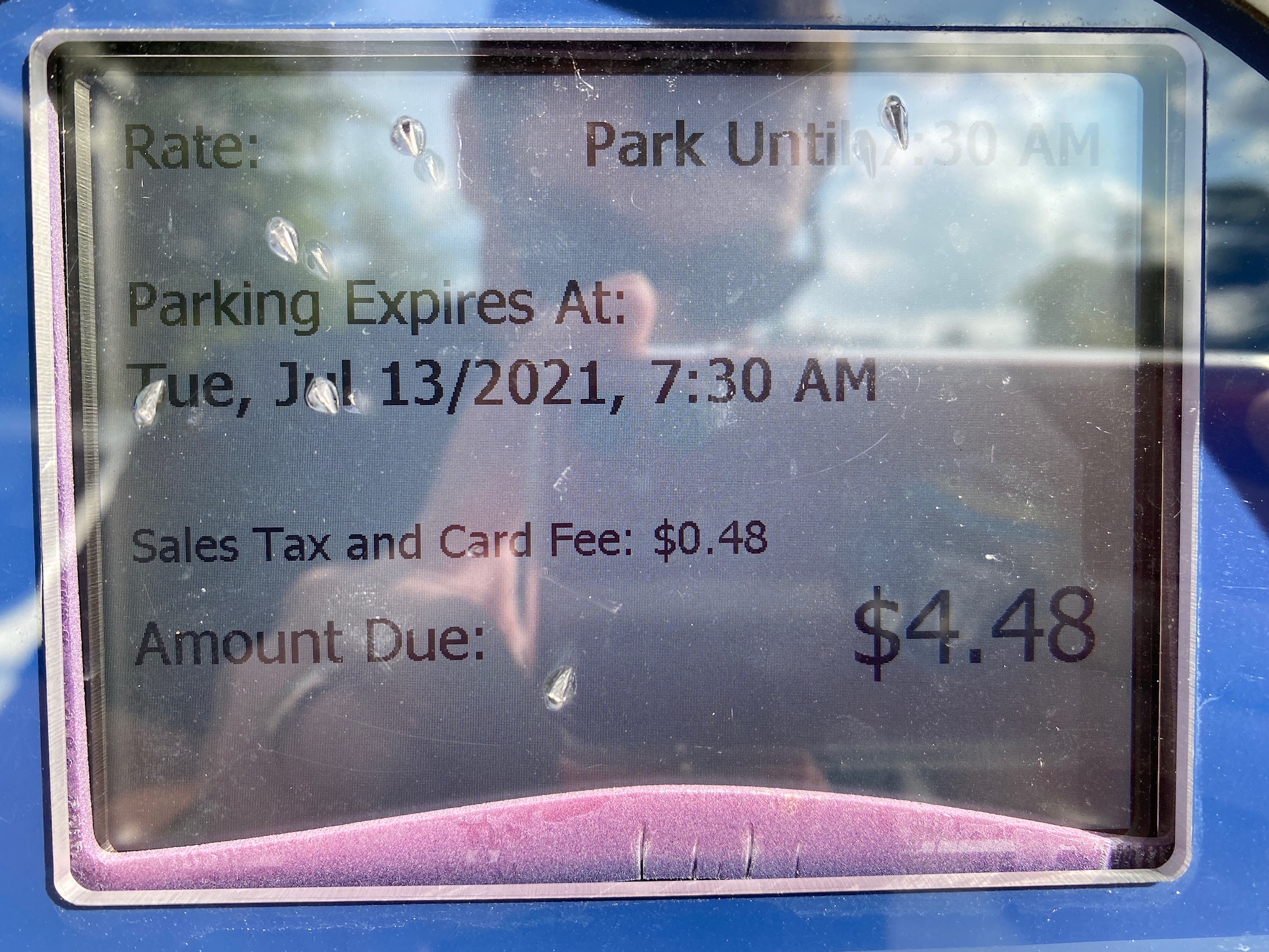 Close-up of a parking meter screen showing a $4.48 payment due for parking until 7:30 AM on July 13, 2021, including a $0.48 sales tax and card fee.
